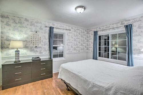 Schlafzimmer mit einem Bett, einer Kommode und Fenstern in der Unterkunft Family-Friendly Wheat Ridge Home! in Wheat Ridge