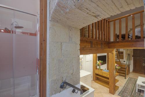 kuchnia i salon z kamienną ścianą w obiekcie Right House - Small Garden in Old Town - Historical Castle District w Cagliari