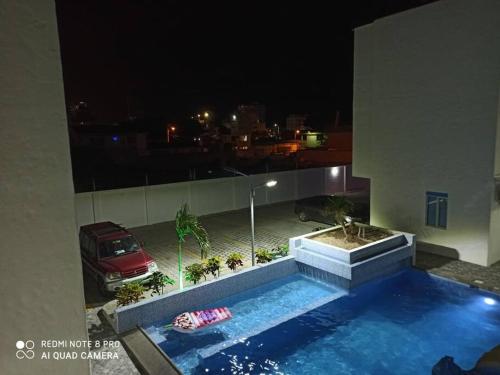 a swimming pool on the side of a building at night at Sol y playa en Santorini Blue, lindo y cómodo dep in Tonsupa