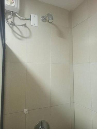 a shower in a white tiled bathroom with a sink at Sol y playa en Santorini Blue, lindo y cómodo dep in Tonsupa