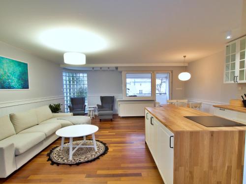 een keuken en woonkamer met een bank en een tafel bij Family Suite Parking 2 Bathrooms 300 m sea in Sopot