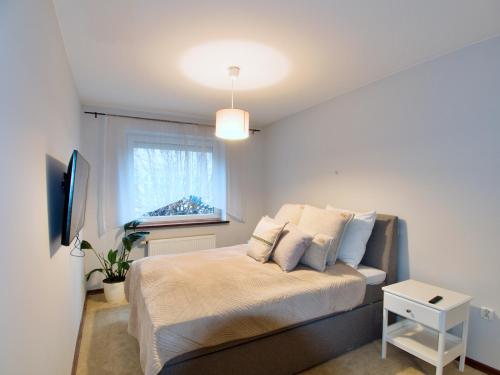 a bedroom with a large bed with a window at Family Suite Parking 2 Bathrooms 300 m sea in Sopot