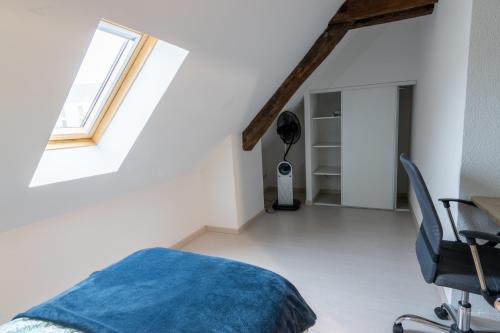um quarto com uma cama, uma secretária e uma janela em Magnifique appartement rénové dans résidence em Saumur