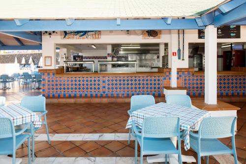 a restaurant with blue chairs and tables and a counter at Bahia Principe Sunlight Costa Adeje - All Inclusive in Adeje