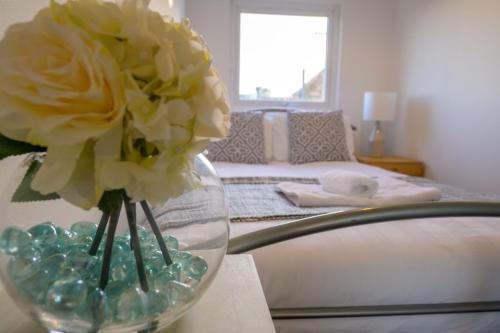 un jarrón con flores sobre una mesa en un dormitorio en Spacious 5 Bed House, perfect for groups, great location, en Liverpool
