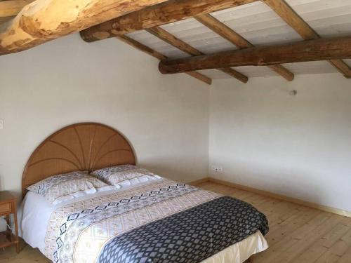 een slaapkamer met een bed in een kamer met houten plafonds bij Maison au Vieil à NOIRMOUTIER in Le Grand Vieil