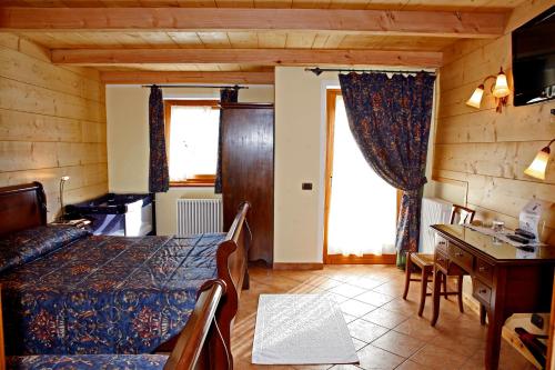 a bedroom with a bed and a desk in a room at Les Combes in La Salle