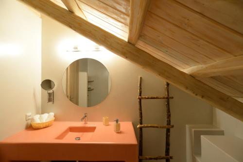 a bathroom with a pink sink and a mirror at FAMILY in Spetses