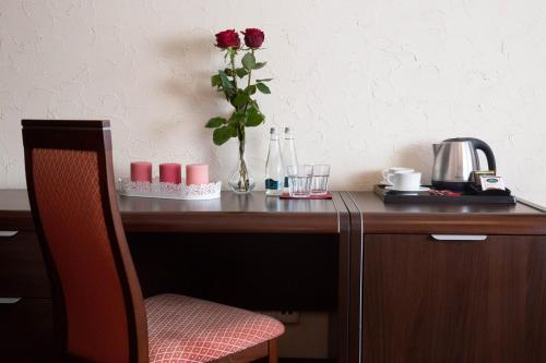 drewniane biurko z wazą z różami w obiekcie Neptun w mieście Legnica