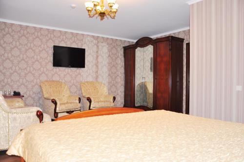 a bedroom with a bed and a tv on the wall at Evropeyskiy in Kyiv