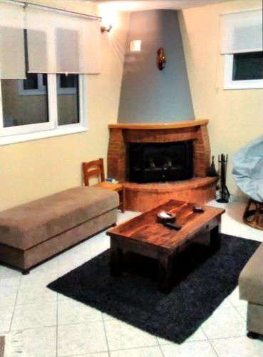 a living room with a couch and a fireplace at POLYTIMI HOUSE in Kalavrita