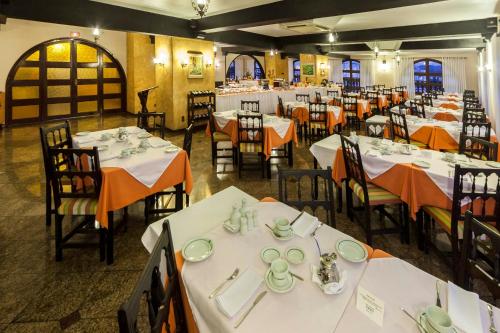 a dining room with white tables and chairs at Hotel Tannenhof in Joinville