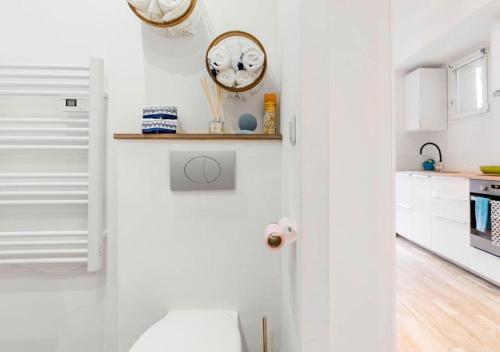 une cuisine blanche avec une horloge sur le mur dans l'établissement Les Bords de l'Estaque x Studio Braque, à Marseille