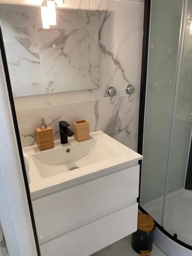 une salle de bain blanche avec un lavabo et une douche dans l'établissement Vue sur l’eau, au Cap d'Agde