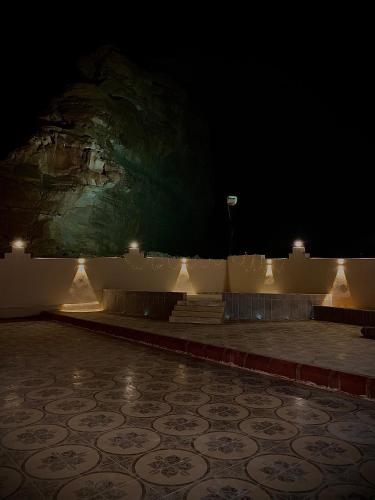 a room with a stone floor and a stone wall with lights at منتجع مرايا in AlUla