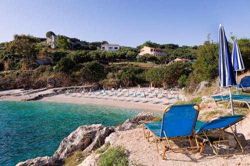 a group of chairs and umbrellas on a beach at Melina Bay Boutique Hotel in Kassiopi