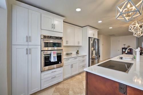 a kitchen with white cabinets and stainless steel appliances at Direct Gulf Access and Lanai Sunny Naples Home! in Naples
