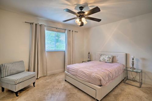 a bedroom with a ceiling fan and a bed and a chair at Direct Gulf Access and Lanai Sunny Naples Home! in Naples