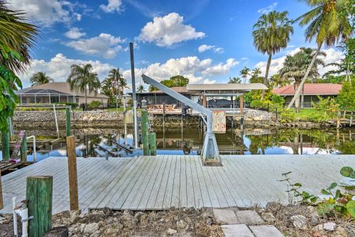 a wooden dock with a slide on a body of water at Direct Gulf Access and Lanai Sunny Naples Home! in Naples
