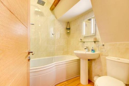 a bathroom with a sink and a toilet and a tub at Sleepy Hollow in Whitby