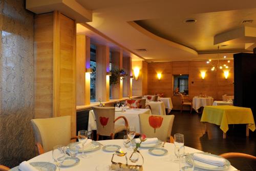 un comedor con mesas blancas y sillas blancas en Le Haut Allier, en Alleyras