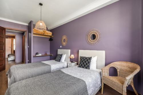 ポルトにあるOporto Santa Catarina Residenceの紫色のベッドルーム(ベッド2台、椅子付)