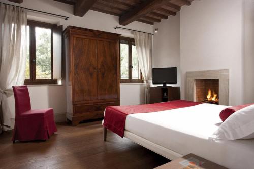 a bedroom with a large bed and a fireplace at Poggio Piglia in Chiusi