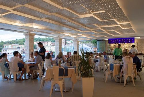 a group of people sitting at tables in a restaurant at Melina Bay Boutique Hotel in Kassiopi
