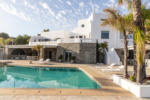 a villa with a swimming pool in front of a house at Villa Ker by Ethos Hospitality- 5 Bedrooms in Mýkonos City