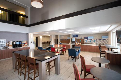 a restaurant with tables and chairs and a cafeteria at Holiday Inn Express Houghton-Keweenaw by IHG in Houghton