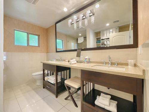 a bathroom with a sink and a toilet and a mirror at Little Paradise Hotel in Palm Springs