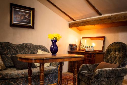 a room with a table and two chairs and a vase with yellow flowers at Pałac Gorzanów in Gorzanów