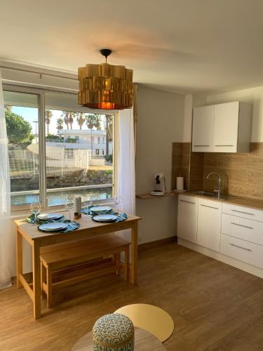 une cuisine avec une table en bois et une fenêtre dans l'établissement Vue sur l’eau, au Cap d'Agde