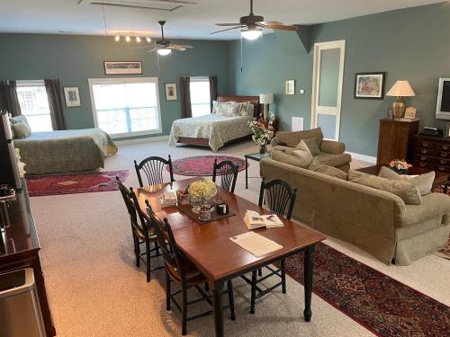uma sala de estar com um sofá, uma mesa e cadeiras em Full Circle Farm Inn em Franklin