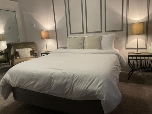 a bedroom with a large bed with white sheets and pillows at Hotel Phillips in Bartlesville