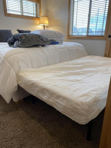 two beds in a bedroom with white sheets at The Raspberry Garden in Rexburg