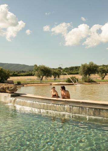 two men sitting in a pool of water at Terme di Vulci Glamping & Spa in Canino