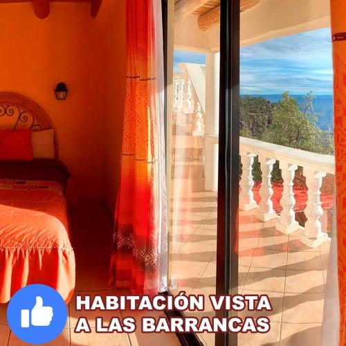 a bedroom with a bed and a glass door with a balcony at Hotel Mansion Tarahumara in Areponapuchi