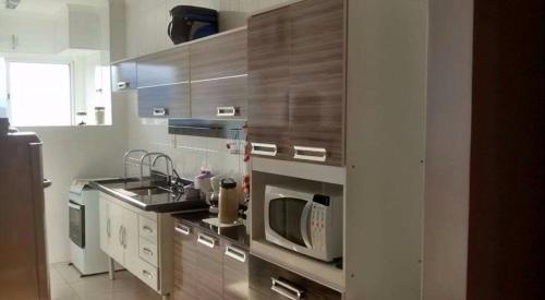 a kitchen with stainless steel appliances and a microwave at VILA CAIÇARA-FRENTE P/MAR in Solemar