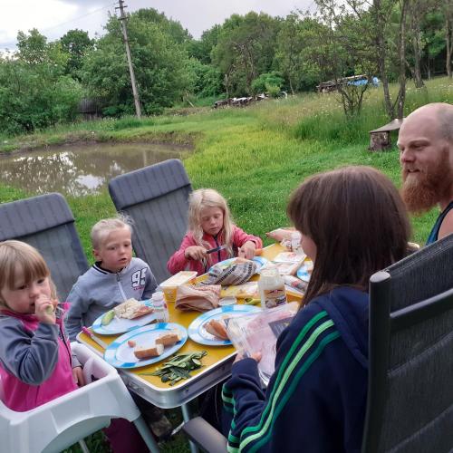a group of people sitting at a table eating food at RUSTIC SEJOUR,Roşia Montana in Roşia Montană