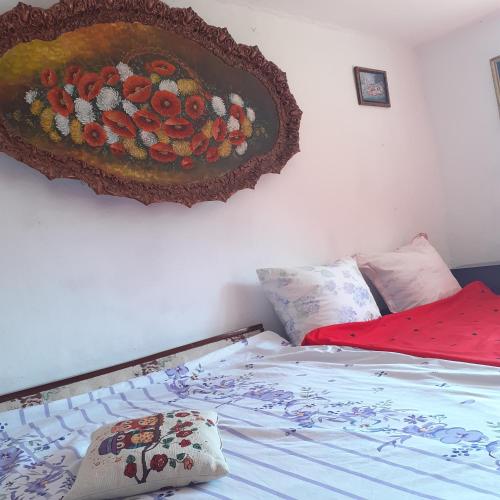a bedroom with a bed with a painting on the wall at RUSTIC SEJOUR,Roşia Montana in Roşia Montană