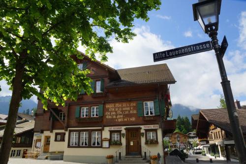 a building with a street sign in front of it at Posthotel Rössli in Gstaad