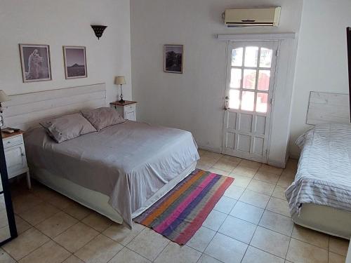 a bedroom with a bed and a window and a door at Casa Bordó Salta in Salta