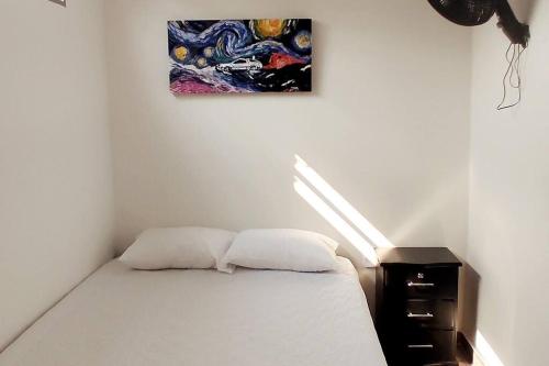 1 dormitorio con 1 cama y una pintura en la pared en Hermoso apartamento con servicios y garaje. en Florencia