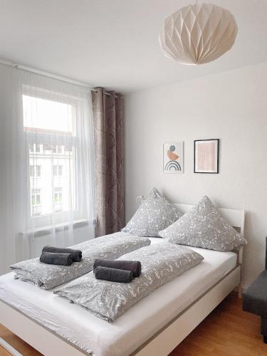 a white bedroom with a bed with two towels on it at Modern & cozy Rooms Leipzig-Gohlis in Leipzig