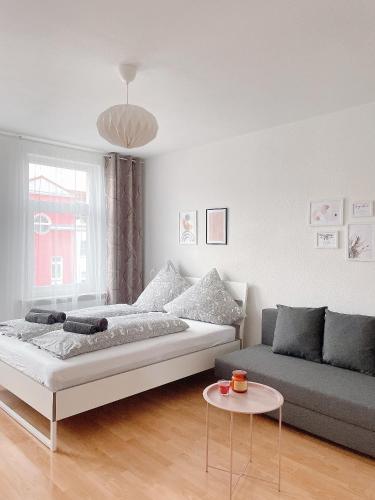 a living room with a bed and a couch at Modern & cozy Rooms Leipzig-Gohlis in Leipzig