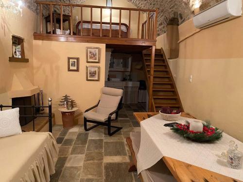 Habitación con cama, mesa y escalera. en GuesthouseKamara, en Monemvasia