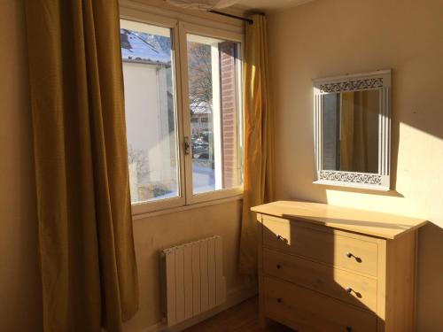 ル・ブール・ドアザンにあるSuperbe appartement à Bourg d'Oisans avec terrasse Sudのベッドルーム(ドレッサー、窓付)