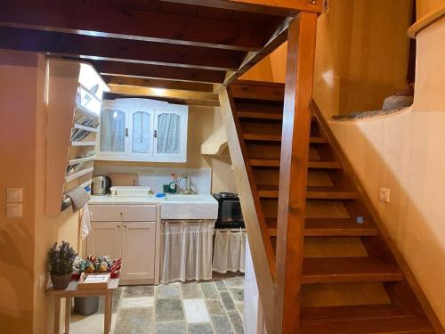 una cocina con una escalera en una casa pequeña en GuesthouseKamara, en Monemvasia