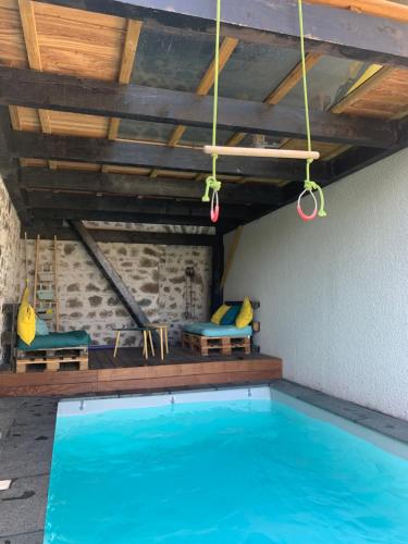 une piscine avec de l'eau bleue dans une maison dans l'établissement Chambres , Mere Veille, à Vaux-en-Beaujolais